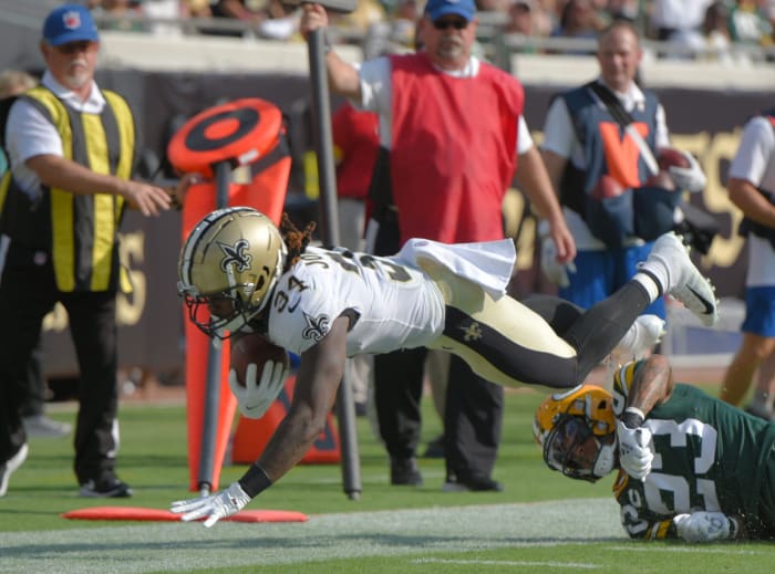 New Orleans Saints RB (34) Tony Jones Jr. dives over Green Bay cornerback Jaire Alexander (23) © Bob Self/Florida Times-Union via Imagn Content Services, LLC
